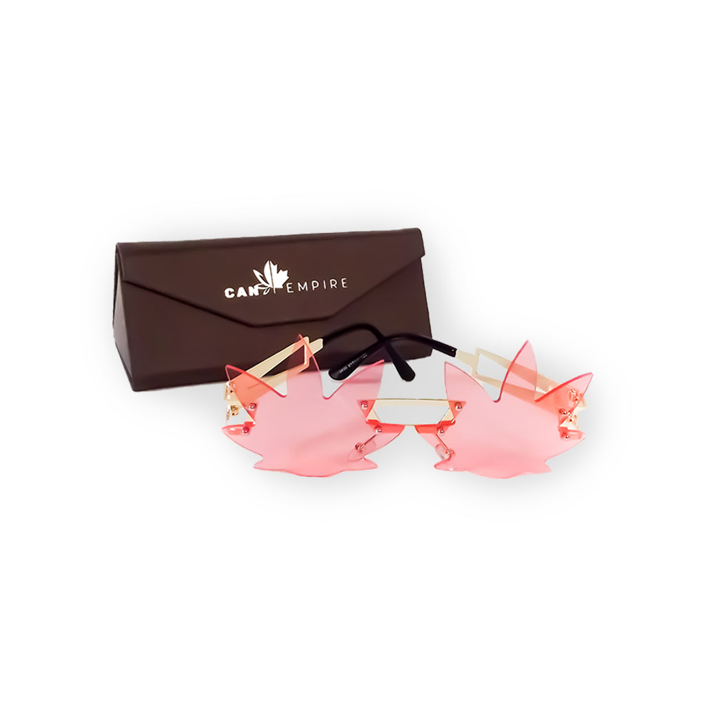 Image des lunettes de soleil de CanEmpire rappelant la forme de feuilles de cannabis. Ces lunettes idéales pour la saison estivale et les festivals sont disponibles en rose et en vert, en plus d'être accompagnées d'une étui de cuir synthétique écologique.